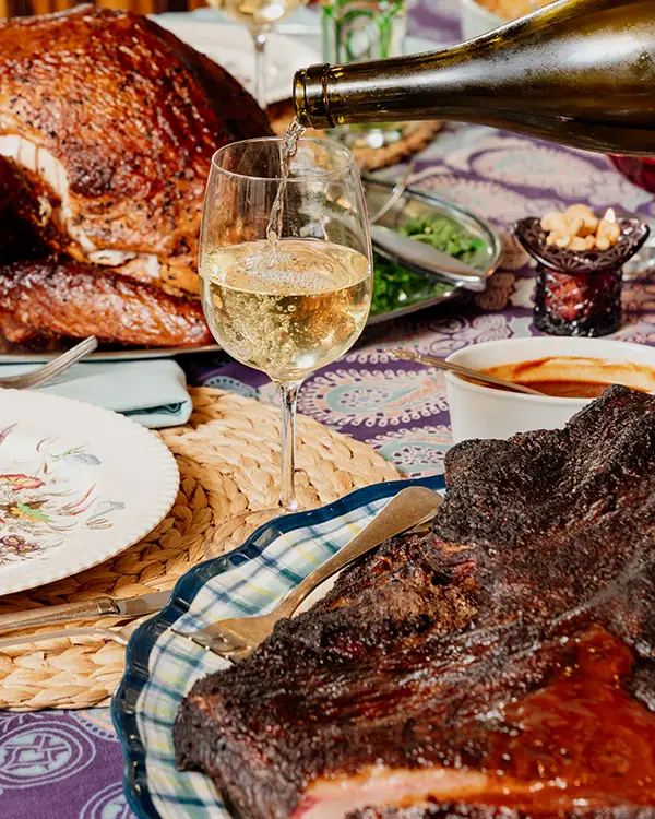 Pouring a glass of wine at holiday table