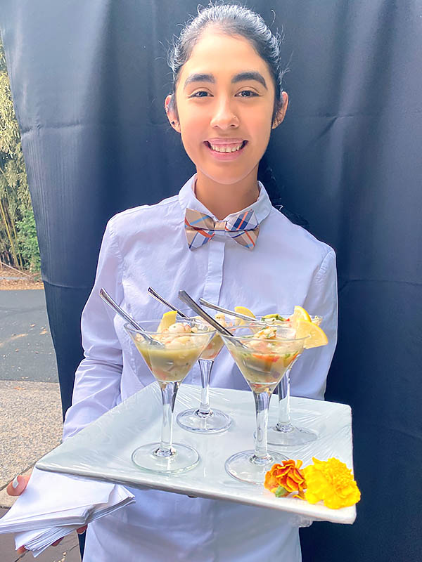 Rocklands catering employee serving platter of appetizers
