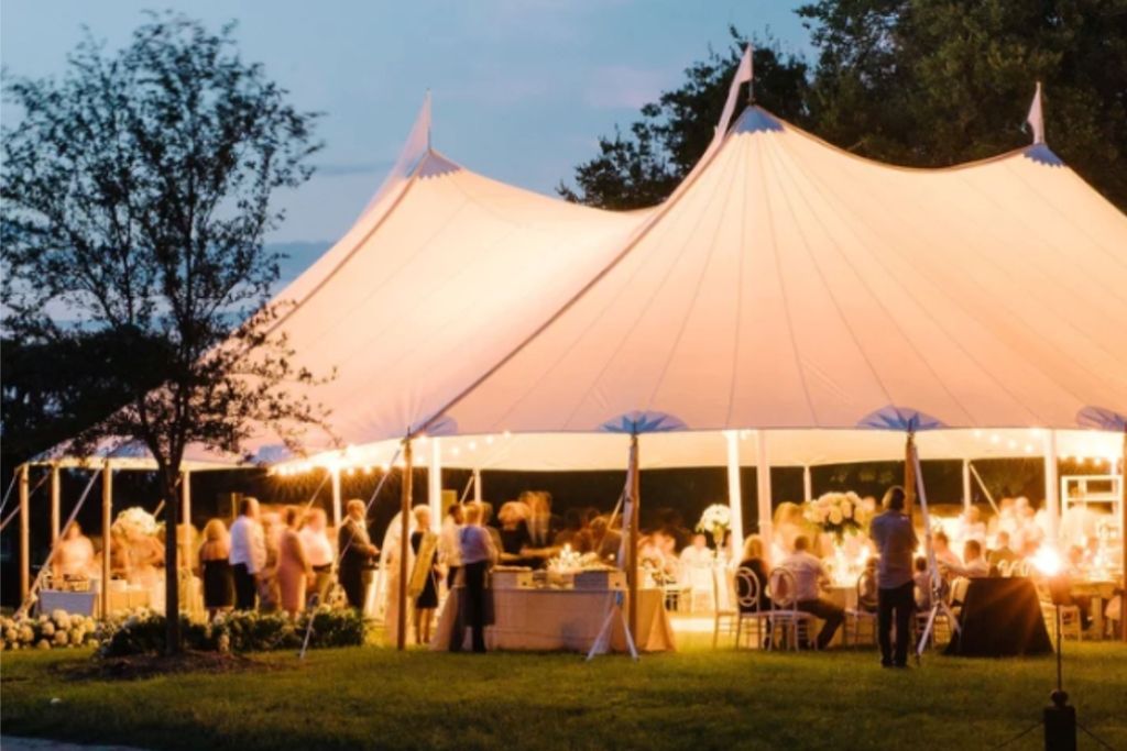 White tent decorated for evening wedding
