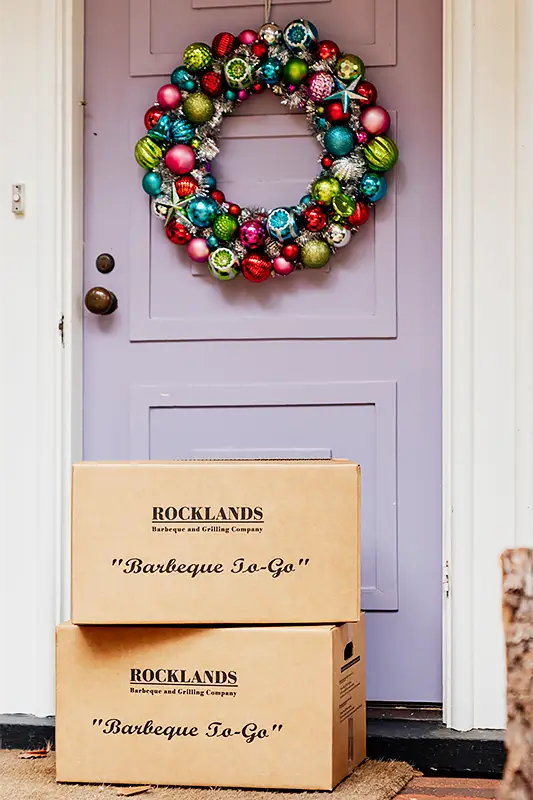 Rocklands boxes in front of a door decorated with holiday wreath