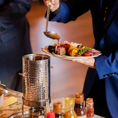Guest spooning Rocklands sauce on to plate